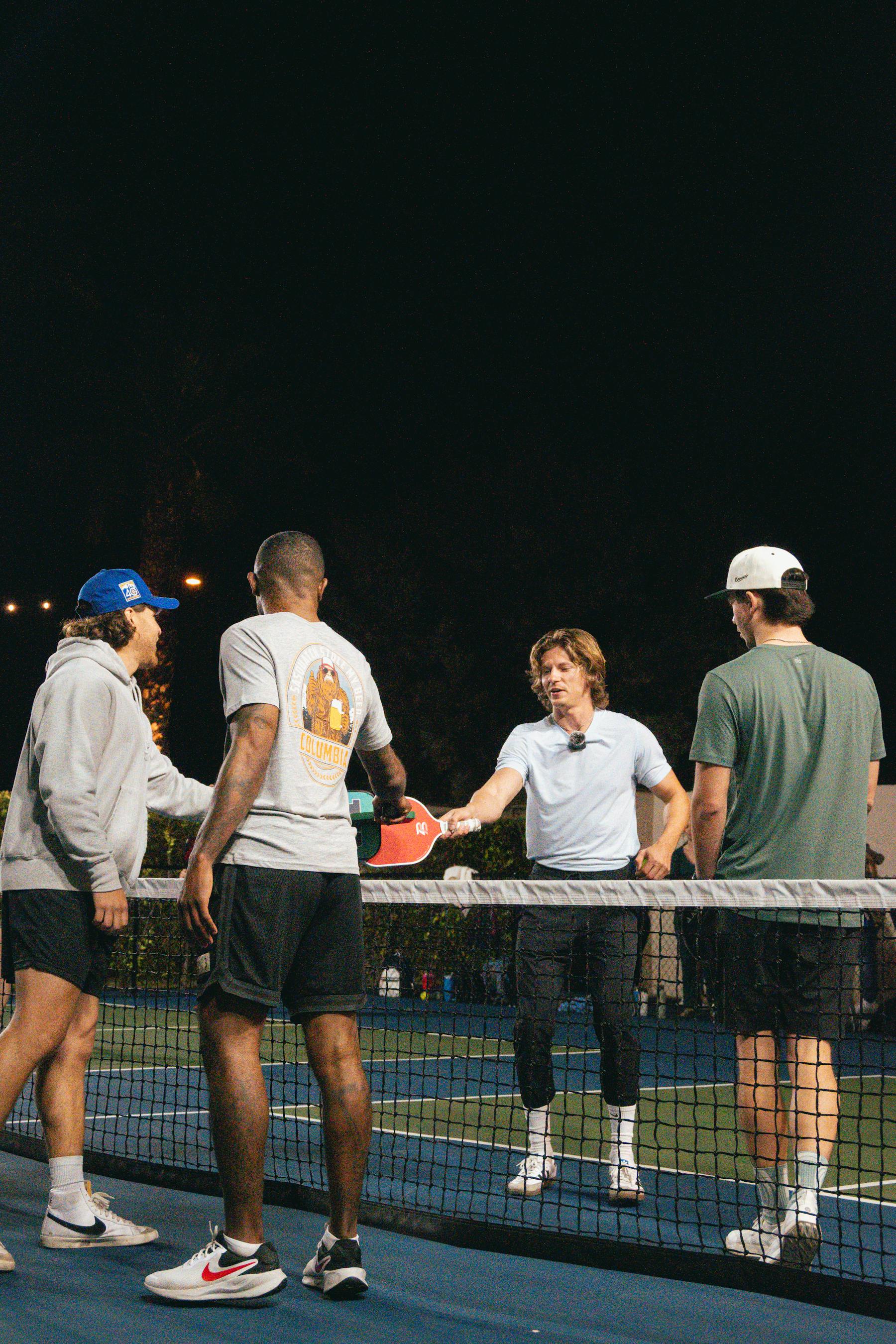 Players shaking hands at the net after a game